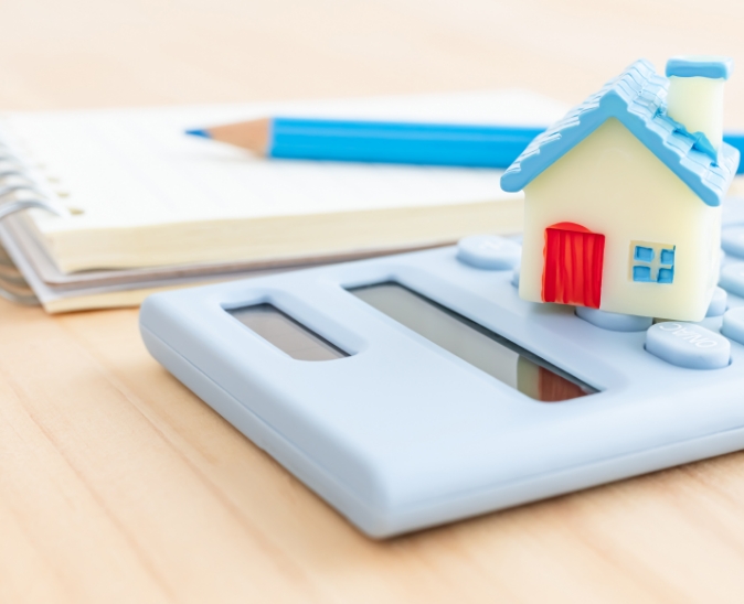 家の模型と電卓の画像